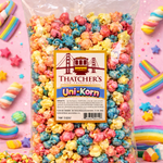 Bag of colorful Thatcher's Uni-Korn popcorn on a pink background with rainbow decorations.