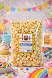 Bag of Thatcher's Birthday Cake popcorn with a colorful birthday-themed background