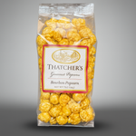 Packaged bourbon popcorn with Thatcher's label on a gray background