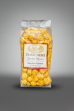 Packaged bourbon popcorn with Thatcher's label on a gray background