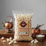 Bag of Taster's Choice kettle popcorn on a wooden table with a copper kettle and small bowl.