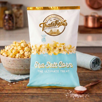 Bag of Thatchers Sea Salt Corn popcorn on a wooden table with popcorn and salt.