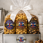 Gourmet popcorn gift set with Thatcher's Popcorn packaging on a marble surface.