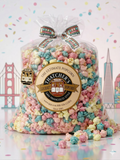 Bag of colorful popcorn with Thacher's Gourmet Popcorn label on a decorative background