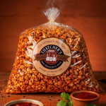 Bag of Thatcher's popcorn with a label on a wooden surface with small bowls and herbs.