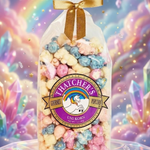 Bouquet of colorful popcorn in a clear bag with a gold bow against a vibrant, multicolored background.