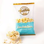 Bag of Thatchers Sea Salt Corn popcorn on a wooden table with popcorn and salt.